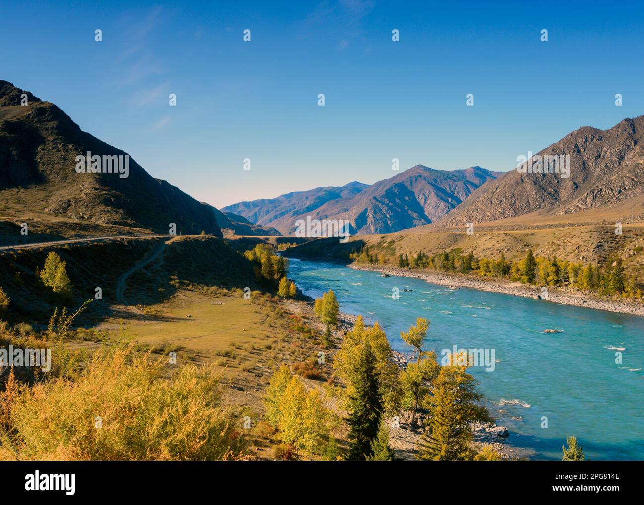 La route de montagne Chuisky Trakt passe sous un rocher à l'ombre près de la rivière Katun en Altaï pendant une journée d'automne en Russie. Banque D'Images