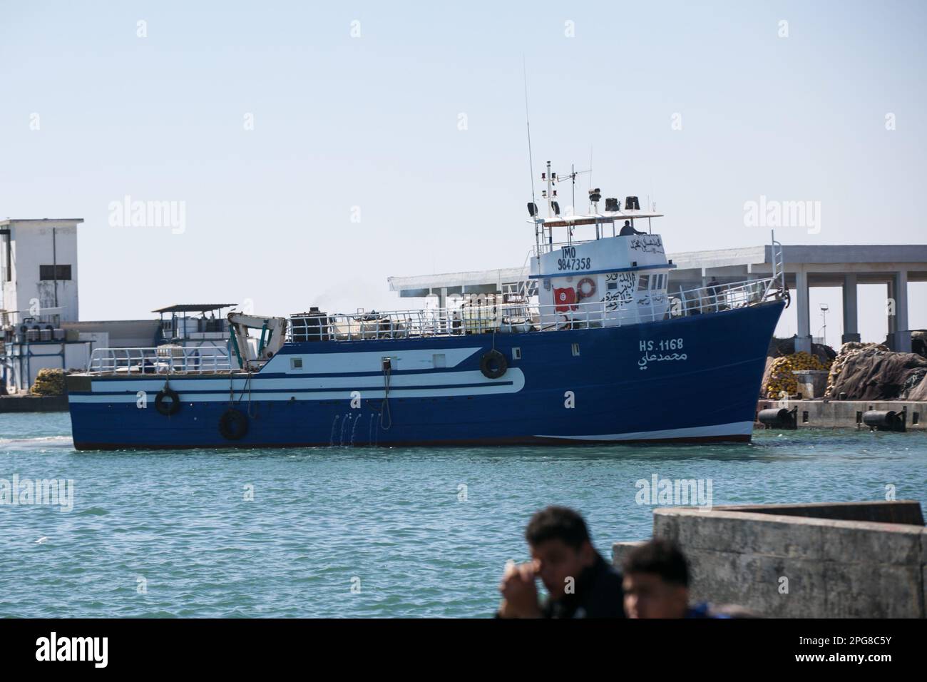 Un bateau de pêche en bois est en route pour entrer dans le port de 18 mars 2023, à Zarzis, Mednine, Tunisie. La ville côtière de Zarzis a une longue tradition de fabrication et de réparation de bateaux de pêche en bois utilisant des méthodes traditionnelles. Les artisans qualifiés de Zarzis utilisent leur expertise pour sélectionner et travailler avec des matériaux locaux de haute qualité tels que le cèdre et le pin. La construction de ces bateaux implique une attention méticuleuse au détail, car ils sont conçus pour résister aux conditions difficiles de l'océan. Les méthodes traditionnelles incluent les outils à main tels que les burins, les scies et les avions Banque D'Images