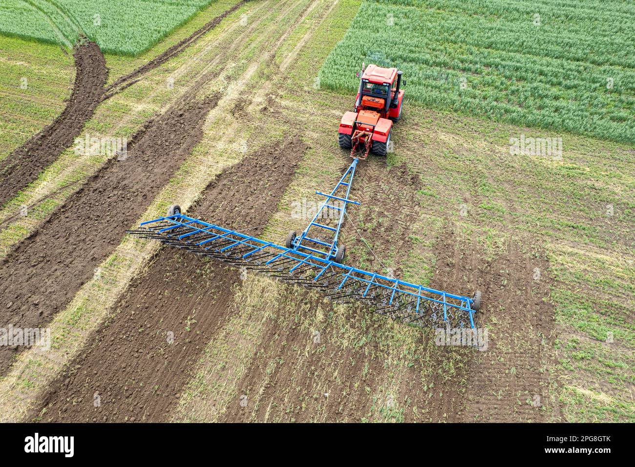 Une grande machine agricole cultive la terre. La vue du dessus. Labourage de terres pour la plantation de cultures. Photos de la vue de l'oiseau avec un quadc Banque D'Images