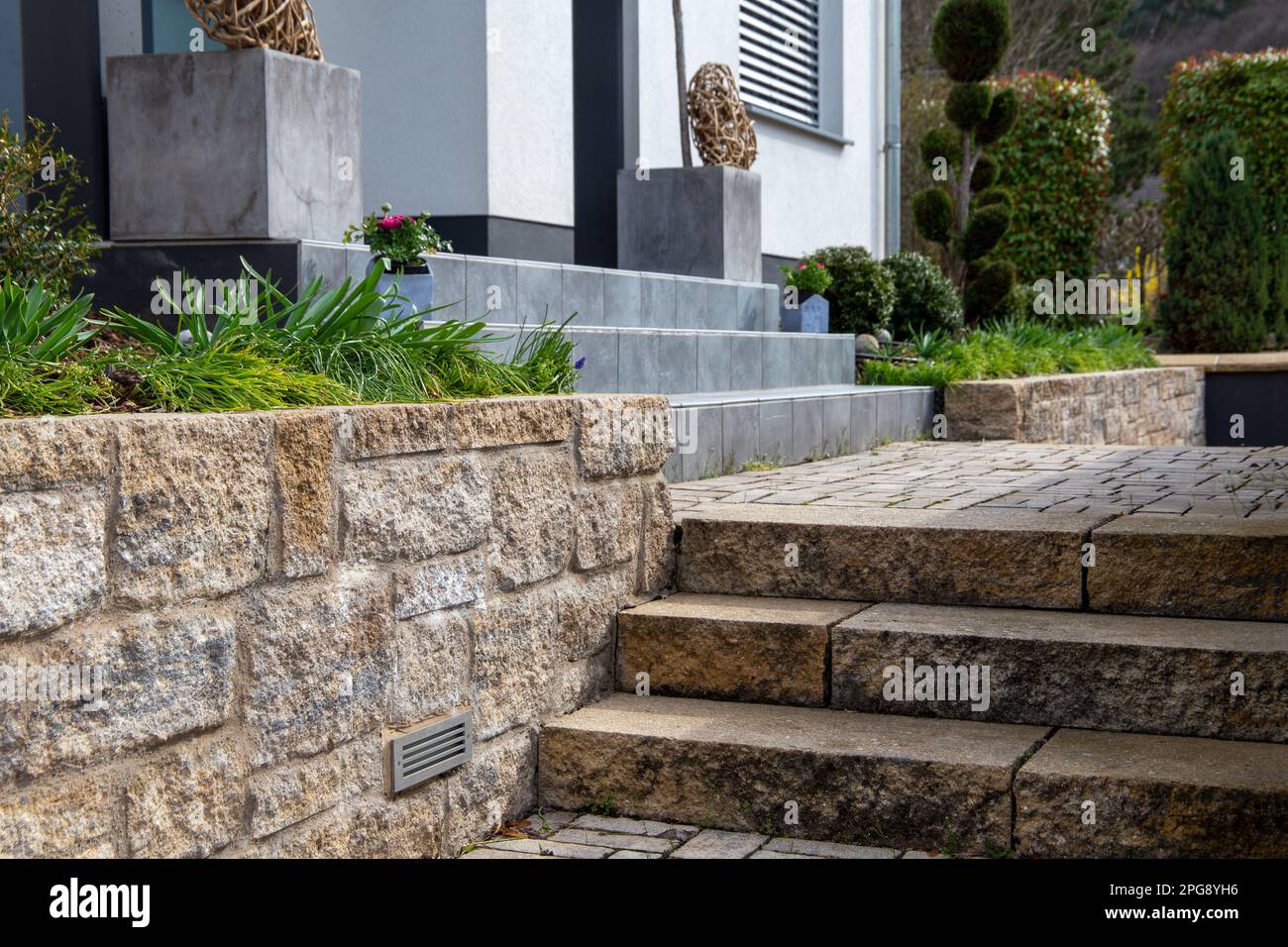 Jardin avant bien entretenu avec des marches en pierre naturelle et en granit Banque D'Images