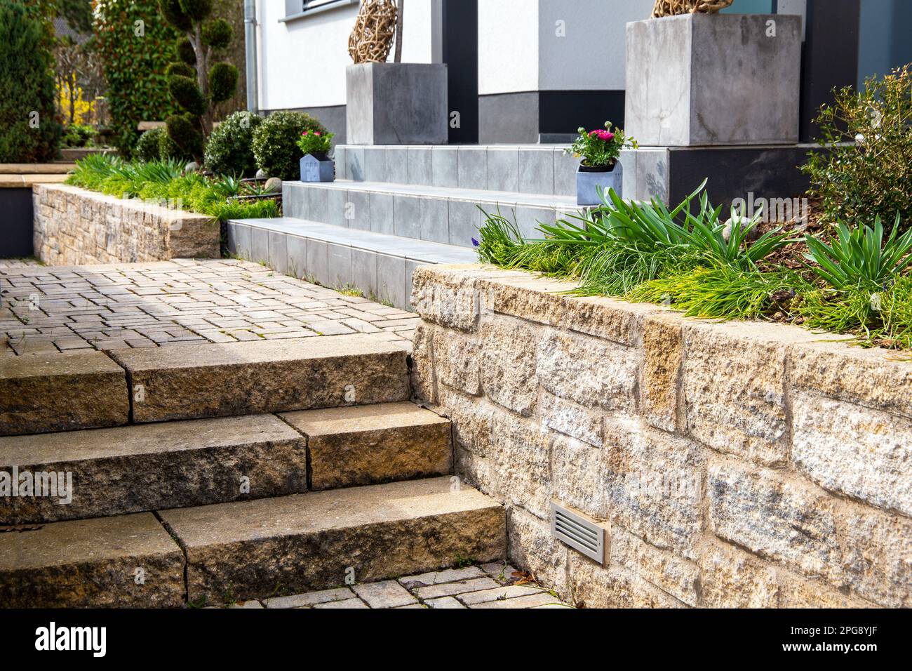 Jardin avant bien entretenu avec des marches en pierre naturelle et en granit Banque D'Images