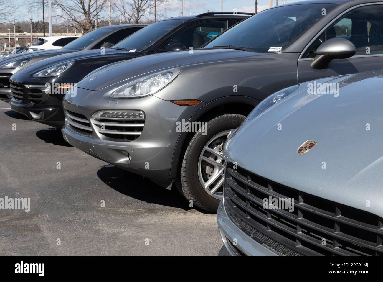 Indianapolis - Circa Mars 2023 : exposition Porsche Cayenne et Macan SUV dans une concession. Porsche propose une gamme complète de voitures de sport et de SUV sportifs. Banque D'Images