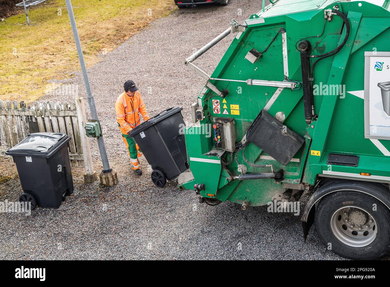 chauffeur de camion à ordures vider les poubelles dans malmkoping suède Banque D'Images