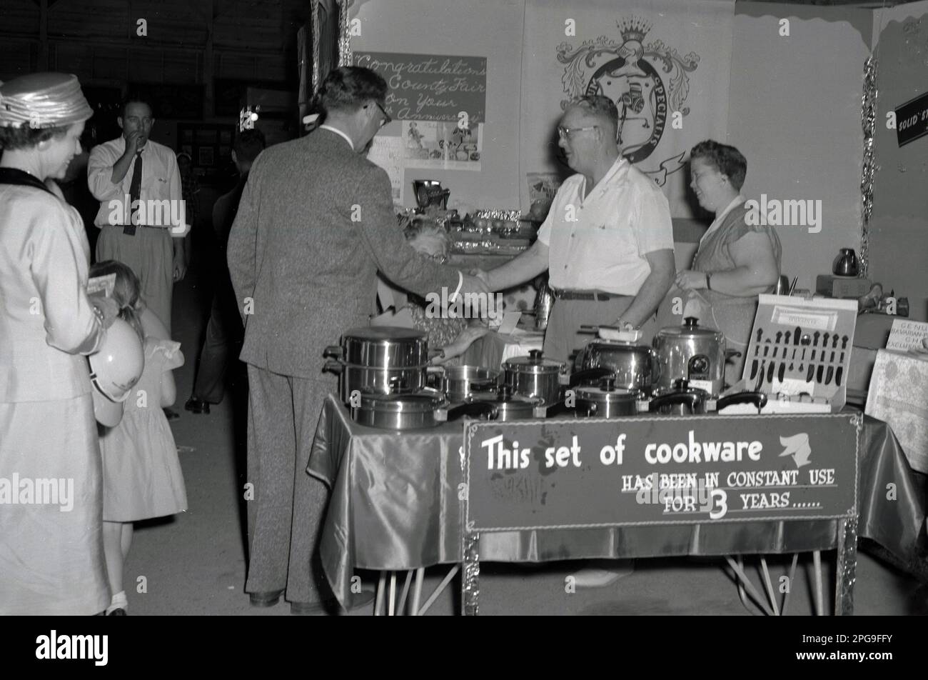 1956, historique, sur un stand d'exposition pour les distributeurs d'ustensiles de cuisine Saladmaster de la foire du comté de Lane, Eugene; Oregon, États-Unis. Des couverts en acier inoxydable sont exposés. Banner explique : « cet ensemble de récipients est utilisé en permanence depuis 3 ans ». L'entreprise a commencé en 1947 avec un seul produit - la machine Saladmaster - et a élargi sa gamme de récipients pour devenir l'une des 100 premières entreprises du Texas à l'horizon 1970s. Banque D'Images