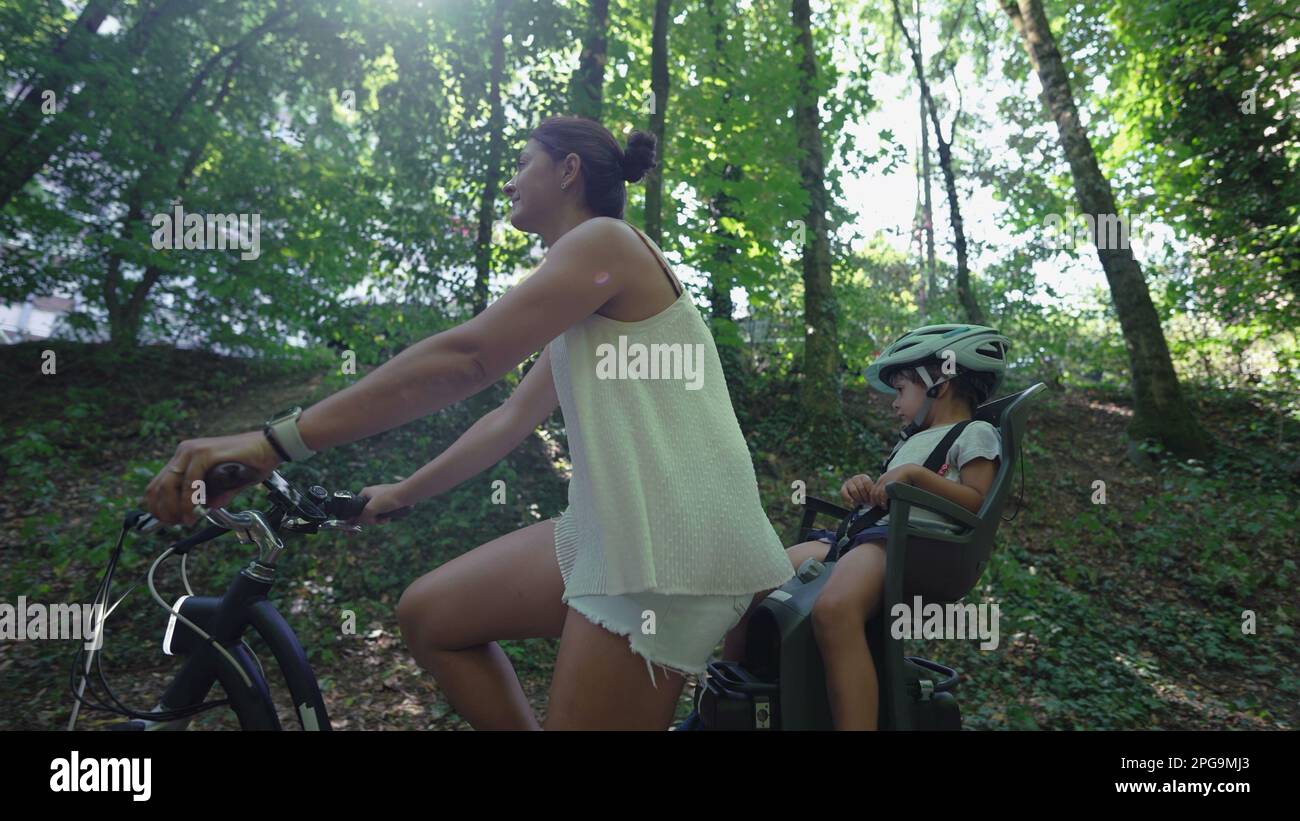 mère à vélo avec enfant assis à l'arrière siège de vélo à l'extérieur dans la route forestière Banque D'Images