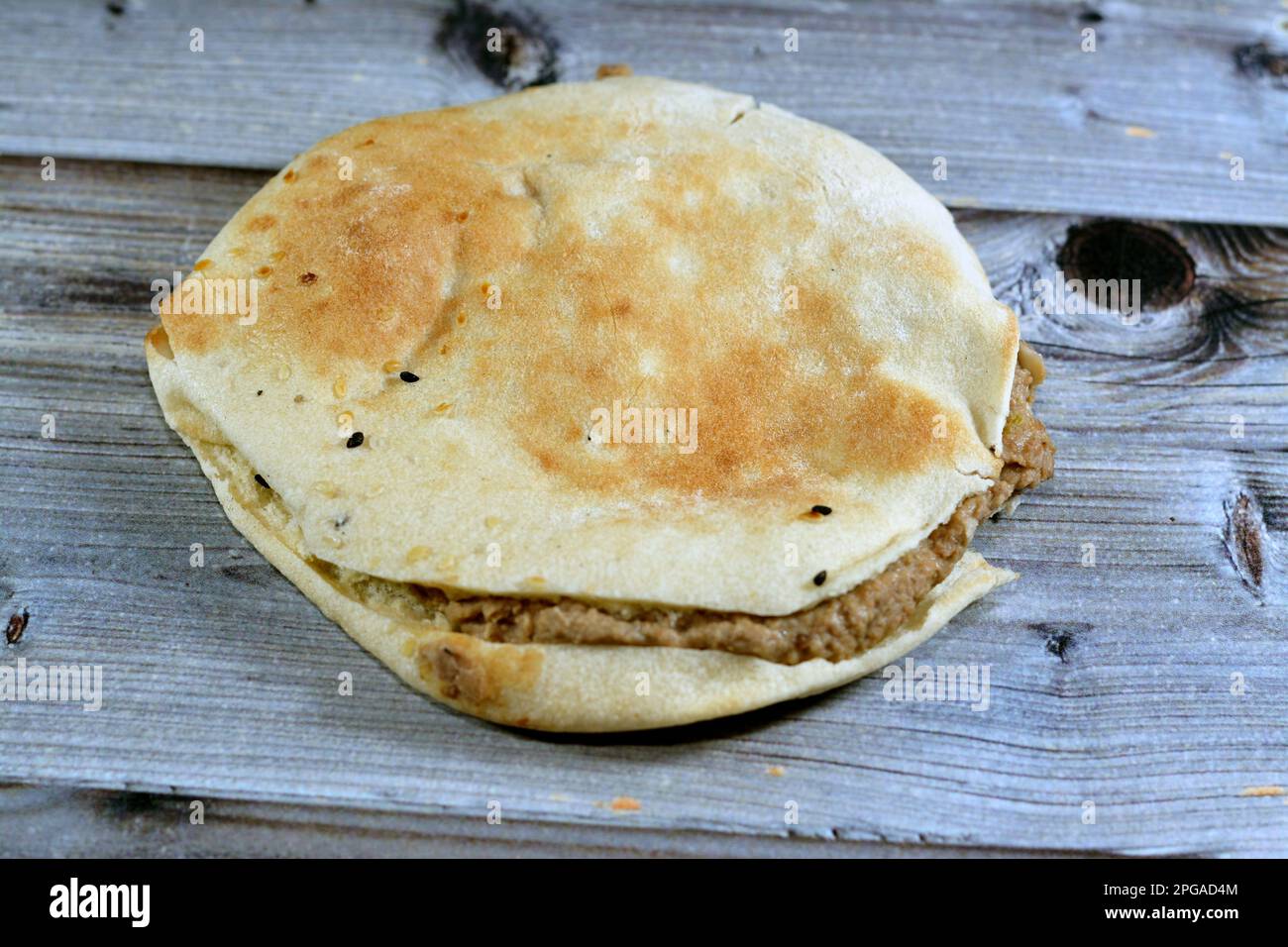 Purée de haricots fava mélangés à de l'huile, tahini de sésame, cumin, épices dans un pain pita syrien de Shami, foyer sélectif du traditionnel populaire sable de haricots égyptiens Banque D'Images