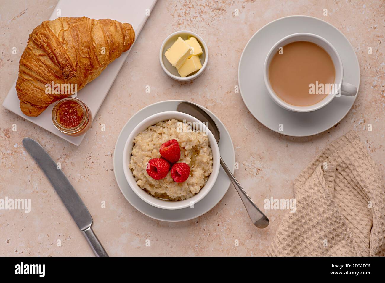 Photographie de nourriture de flocons d'avoine, avoine, porridge, petit déjeuner, croissant, thé, lait, framboises, beurre Banque D'Images