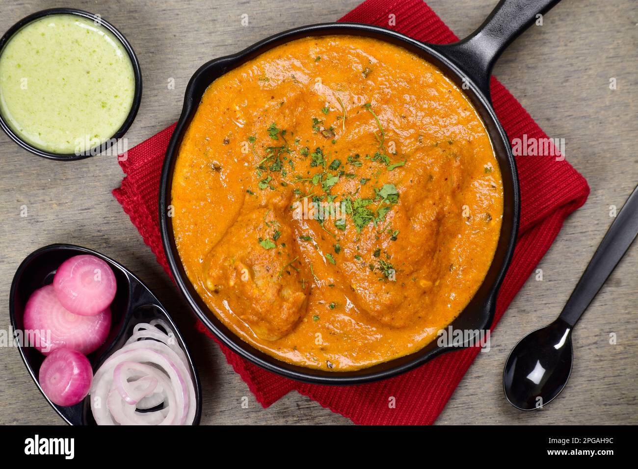 Poulet au beurre crémeux dans une assiette avec chutney à la menthe Banque D'Images