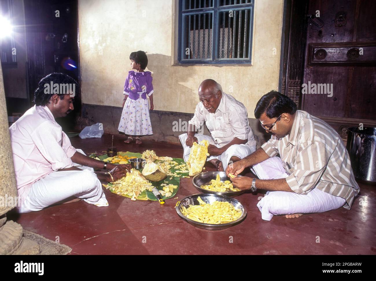 Nattukottai Chettiars; Nagarathars pour séparer le fruit de Jack pour le distribuer aux invités de la fête de mariage à Chettinad, Tamil Nadu, Inde Banque D'Images