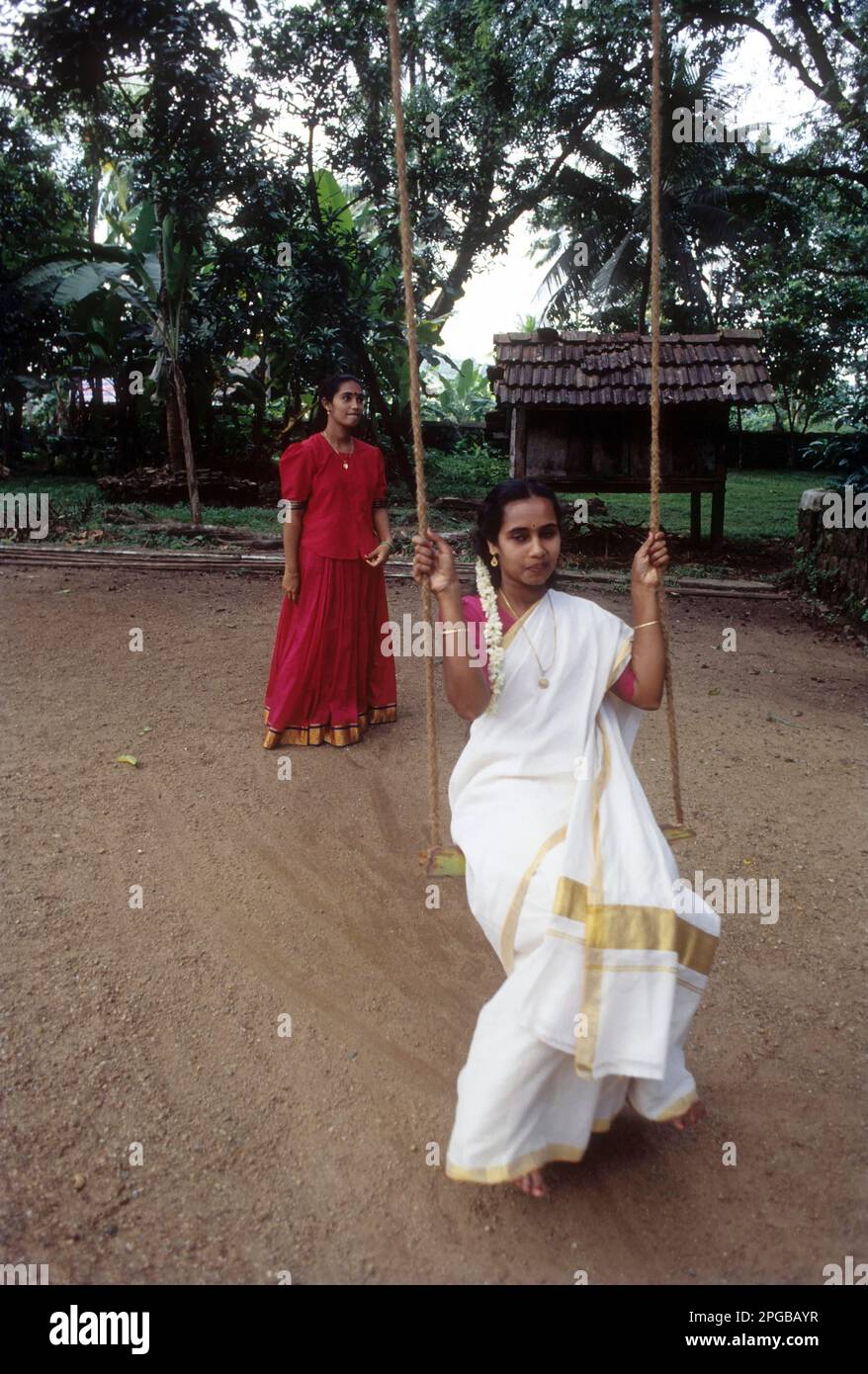 Balançoire; deux filles appréciant des vacances à l'Onam à Aranmula, Kerala, Inde Banque D'Images