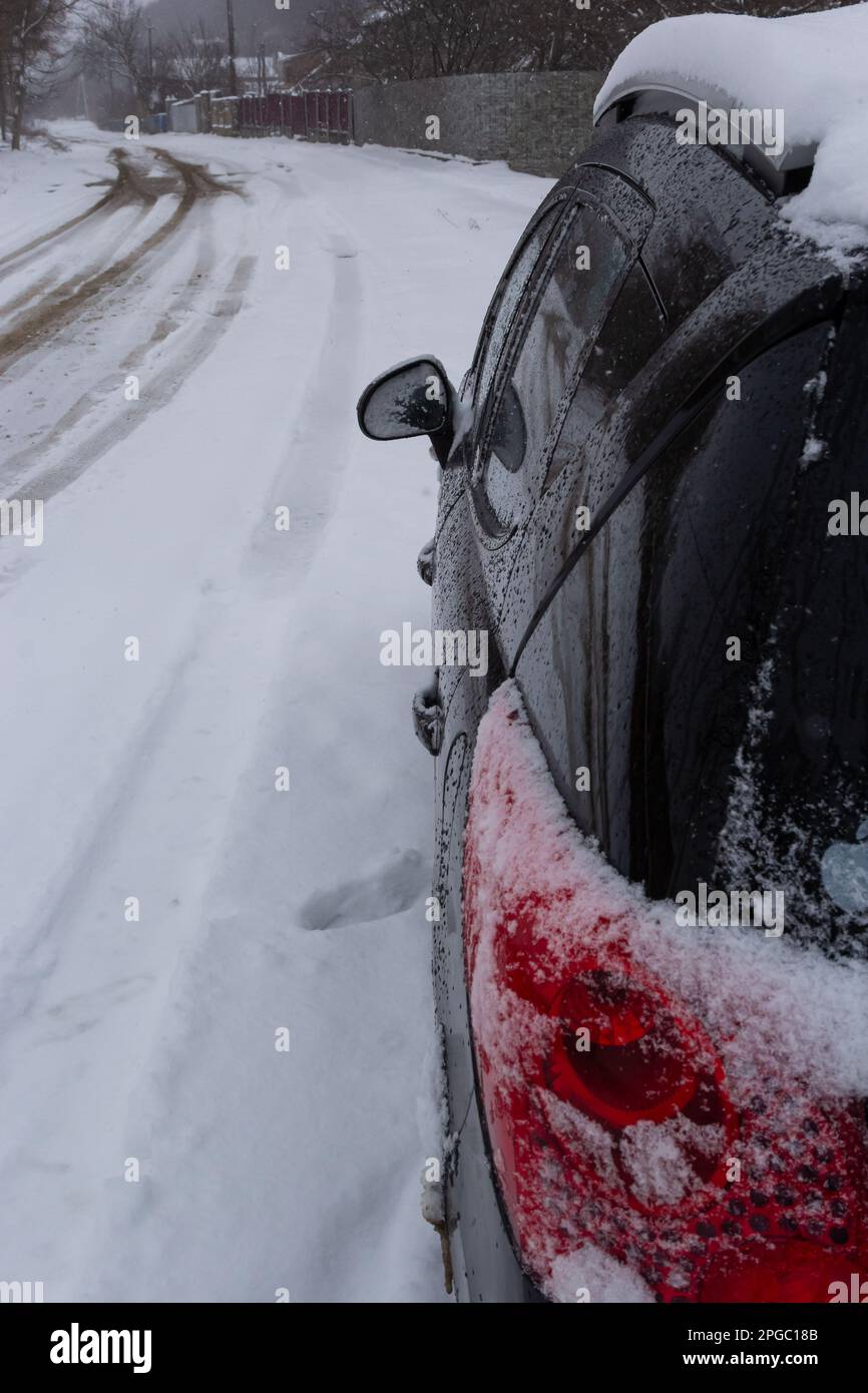 feu arrière de la voiture recouvert de neige après un blizzard en hiver. Banque D'Images