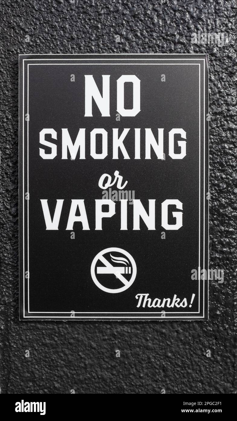 Panneau interdiction de fumer ou de se passer. Panneau anti-vapotage ou cigarette électronique sur fond noir. Personne, mise au point sélective, photo de rue Banque D'Images