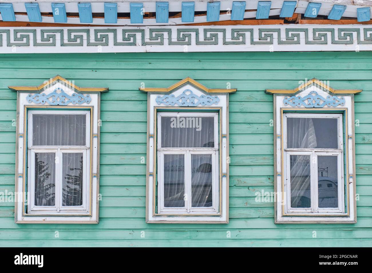 Fenêtres avec architraves en bois sculpté. Façade de la maison tatar marchande typique, construite au 19th siècle sur la rue Kayum Nasyri, Kazan, Russie. Architecture Banque D'Images