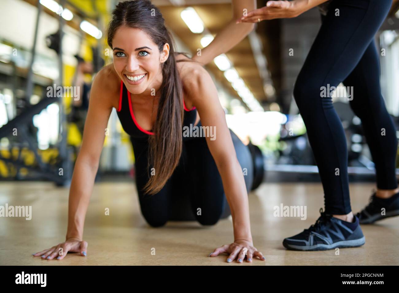 Belle femme faisant des exercices en salle de gym avec entraîneur personnel ensemble. Sport, concept de personnes Banque D'Images