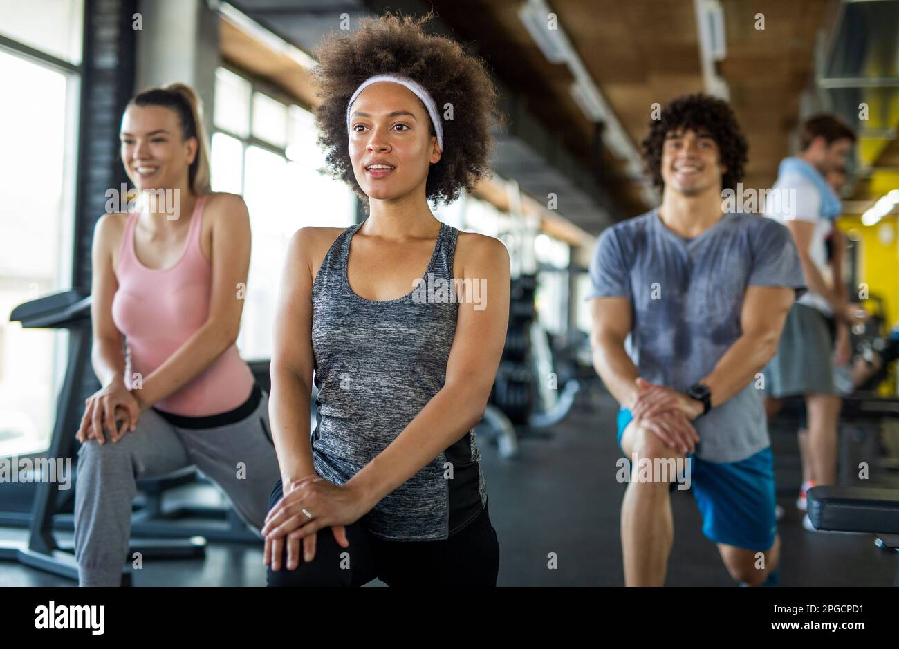 Groupe de jeunes, amis souriant et profiter du sport dans la salle de gym. Concept d'exercice, d'entraînement. Banque D'Images