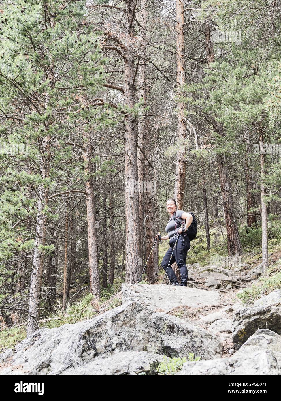 Une femme aventureuse vêtue de vêtements décontractés fait une randonnée sur un sentier isolé, en admirant la nature luxuriante des forêts de Norways et des vues incroyables de son point de vue Banque D'Images