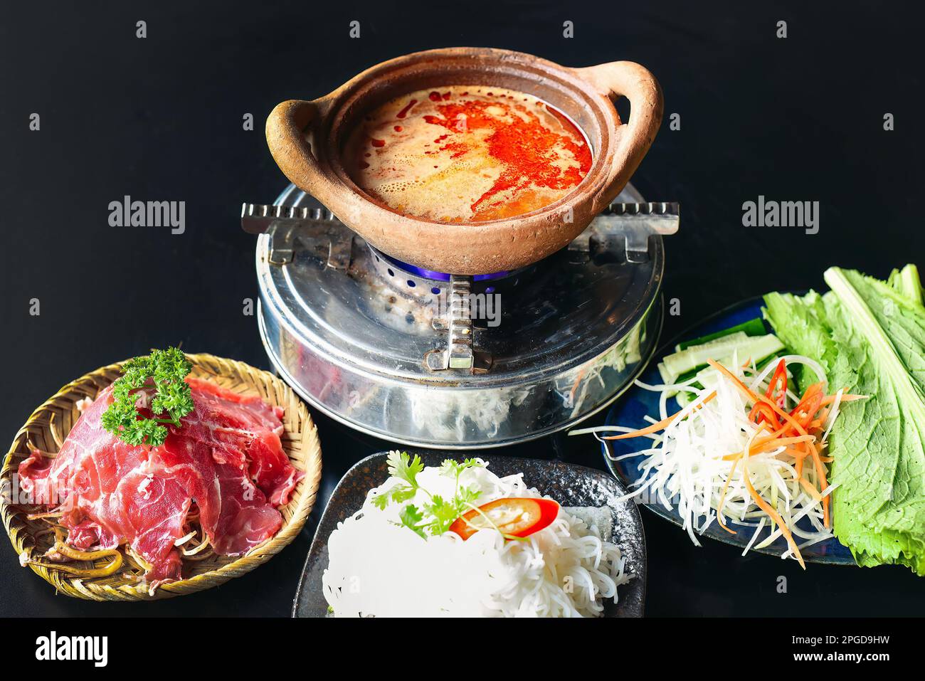 Hot pot coréen épicé avec viande de boeuf et nouilles sur fond noir Banque D'Images