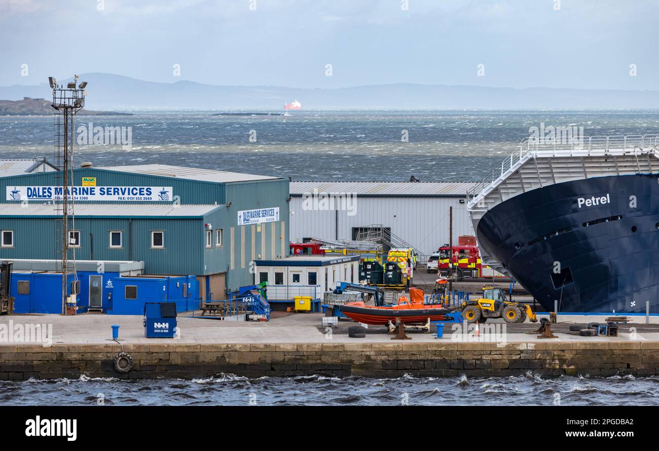 Leith Harbour, Édimbourg, Écosse, Royaume-Uni, 22nd mars 2023. Navire pétrel listing à 45 degrés: Le Pétrel, un navire de recherche, a été acheté et équipé par feu le co-fondateur de Microsoft Paul Allen. Les vents forts ont joué un rôle dans le logement sec de Dales Marine. Des véhicules d'urgence sont présents. Crédit : Sally Anderson/Alay Live News Banque D'Images