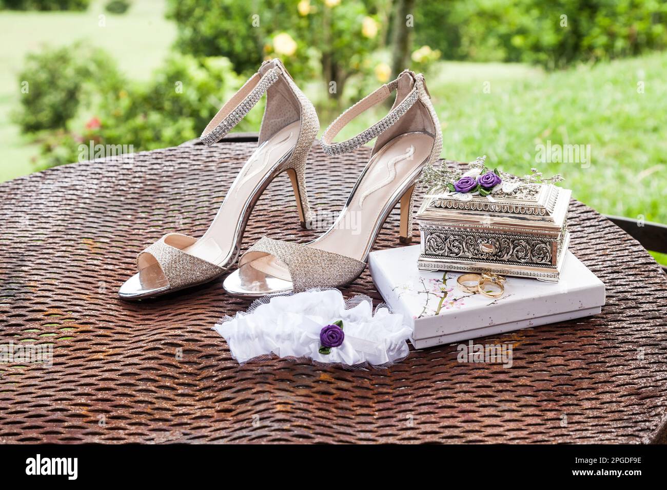 Mariage. Accessoires de mariée: ligue, anneaux de mariage près des chaussures de mariée sur des talons hauts Banque D'Images