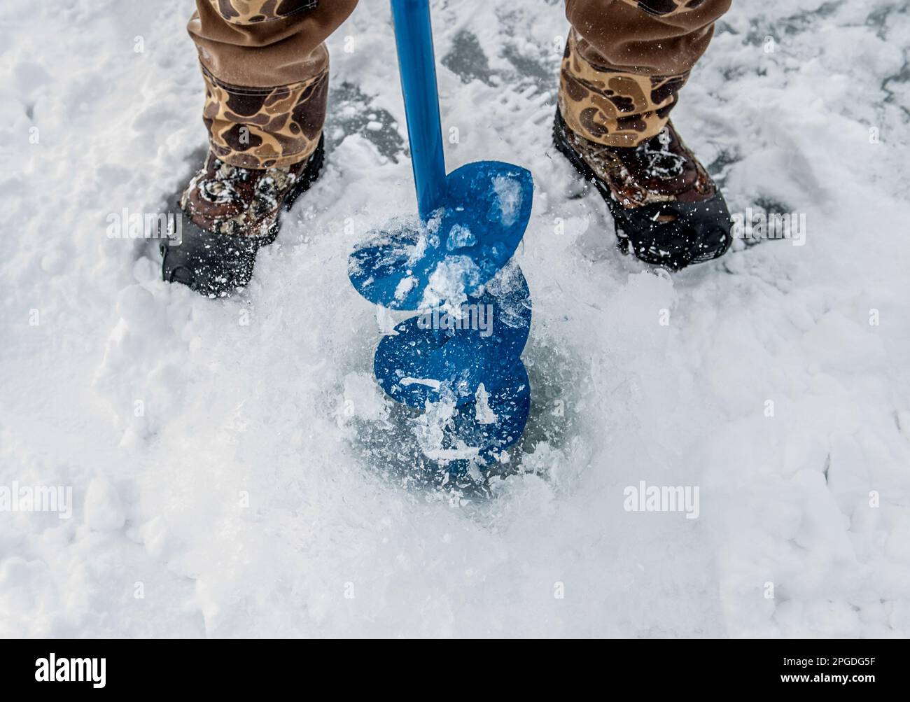 Forage dans la glace pour un trou de pêche sur glace. Banque D'Images
