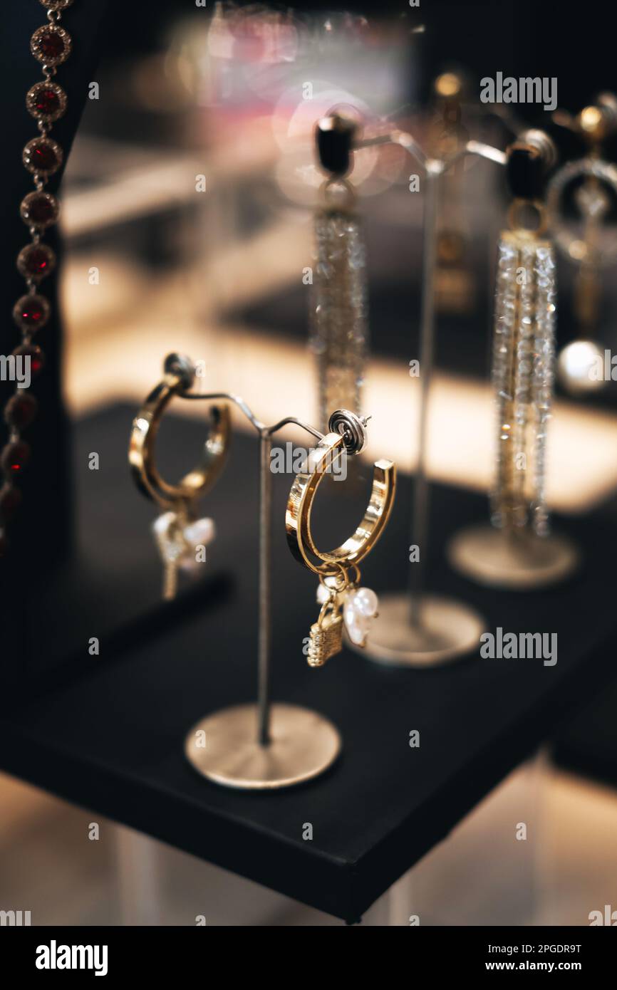 Bijoux boucles d'oreilles dorées sur la vitrine de la boutique d'accessoires pour femmes Banque D'Images