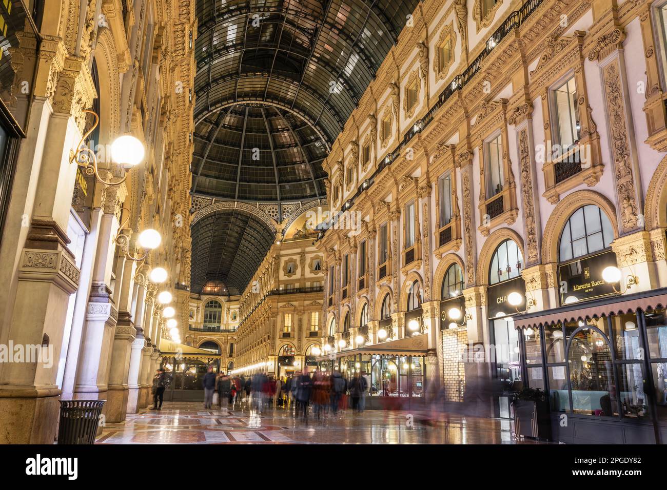 Milan, Italie illumina l'intérieur de la galerie Vittorio Emanuele II la nuit, arcade datant du 19th siècle avec boutiques et foule non identifiable sur la place principale du Duomo Banque D'Images