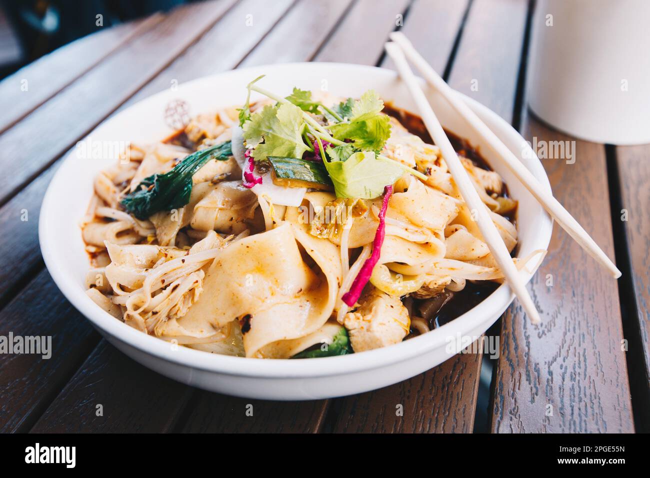 Le plat chinois le plus célèbre de la province de Shaanxi, appelé nouilles biang biang, également connu sous le nom de youpo chimian servi avec du poulet épicé à l'huile de chilis Banque D'Images