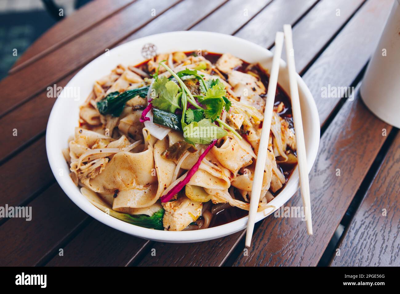 Le plat chinois le plus célèbre de la province de Shaanxi, appelé nouilles biang biang, également connu sous le nom de youpo chimian servi avec du poulet épicé à l'huile de chilis Banque D'Images