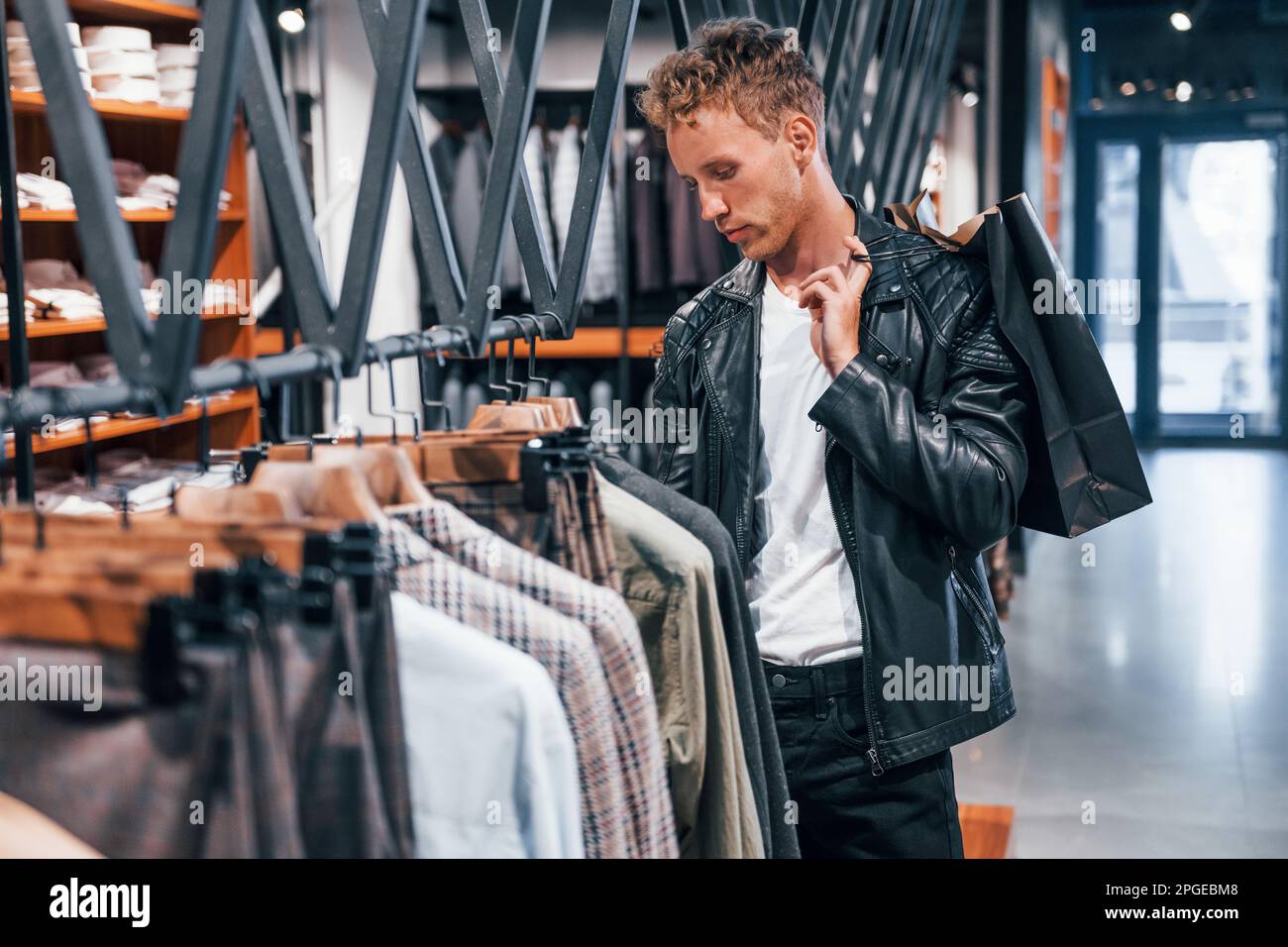 Grand choix. Jeune homme dans un magasin moderne avec de nouveaux