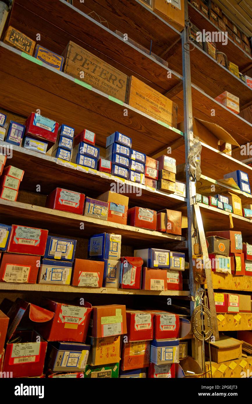 Divers écrous et boulons dans de nombreuses boîtes sur les étagères et les munitions dans des boîtes en bois ci-dessus dans un magasin de quincaillerie qui est plus de cent ans encore moi Banque D'Images