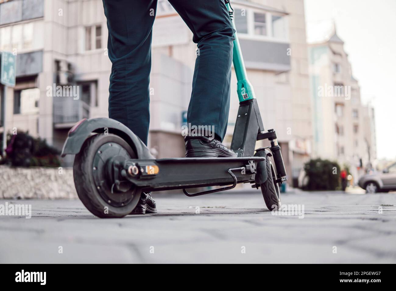 Homme d'affaires inconnu en costume classique sur scooter mobile électrique. un homme d'affaires loue un scooter dans la rue de la ville. transpo écologique et moderne Banque D'Images