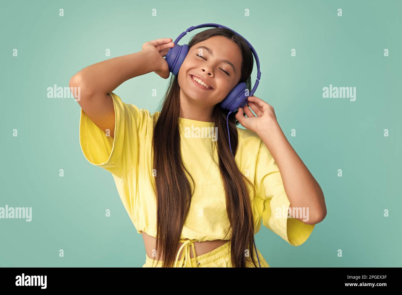 Une jeune fille dans un casque écoute de la musique. Accessoire de casque  sans fil. L'enfant aime la musique dans les écouteurs sur fond bleu Photo  Stock - Alamy