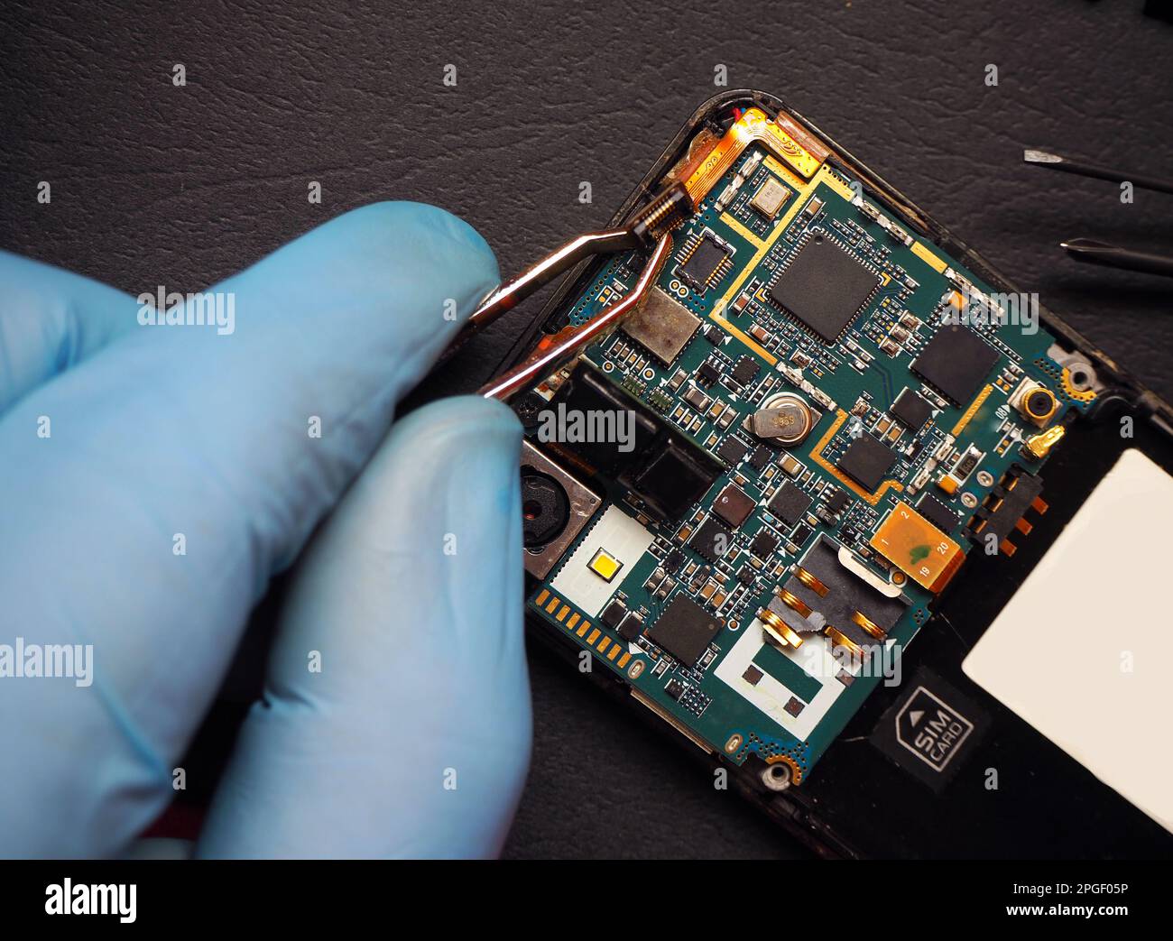 Réparation à l'intérieur du téléphone portable. Carte de circuit imprimé du smartphone. Ingénierie de maintenance des appareils de haute technologie. Banque D'Images