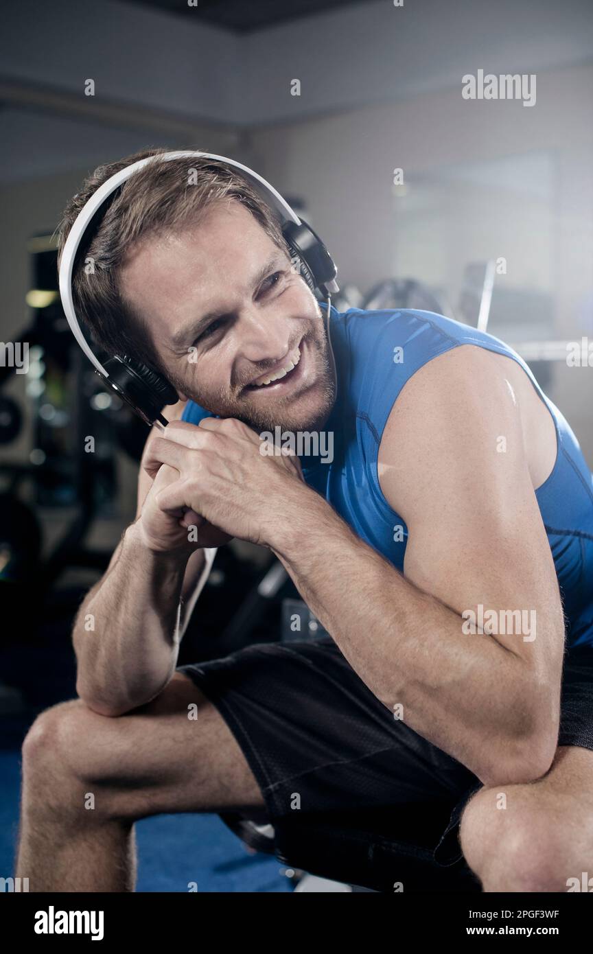 Homme d'âge moyen prenant le repos après l'entraînement dans la salle de gym et à l'écoute de la musique, Bavière, Allemagne Banque D'Images