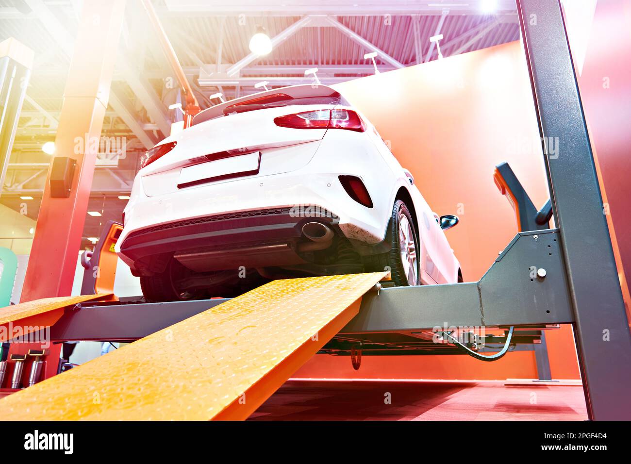 Voiture sur un ascenseur dans un service de diagnostic Banque D'Images Voiture sur un ascenseur dans un service de diagnostic Banque D'Images