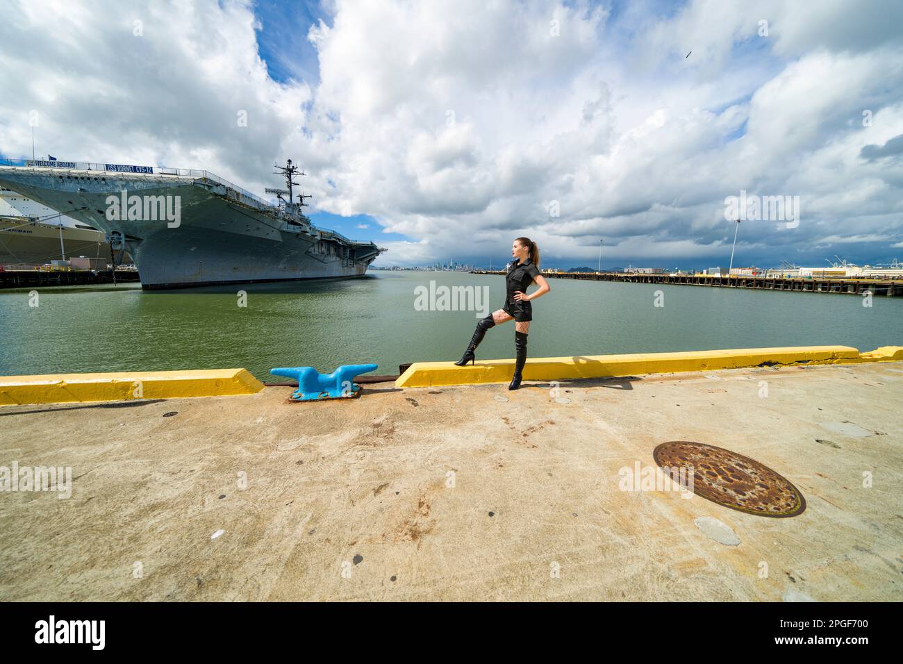 Jeune femme à grand angle debout devant l'USS Hornet | Goth style Banque D'Images