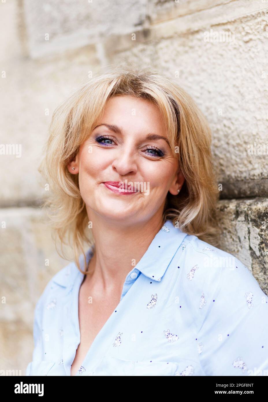 bonne jeune femme blonde avec les yeux bleus dans une chemise bleue Banque D'Images