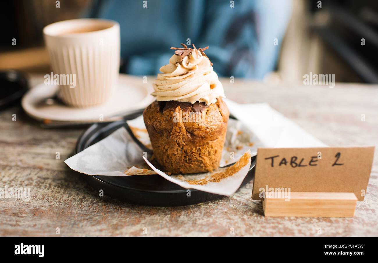 un cupcake non emballé sur une table dans un café avec du café Banque D'Images