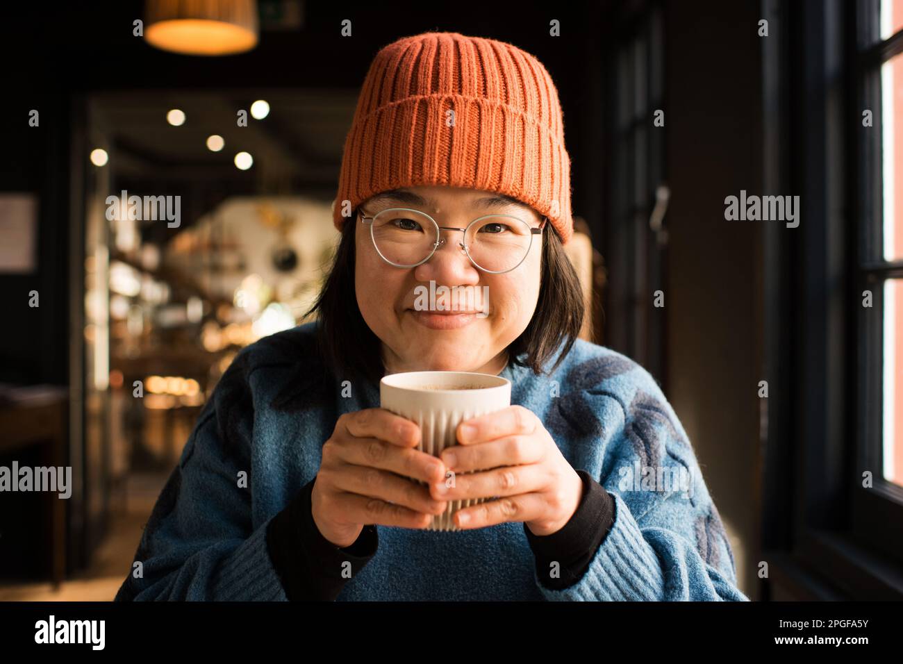 Portrait d'une femme asiatique souriant tenant une tasse de café chaud Banque D'Images