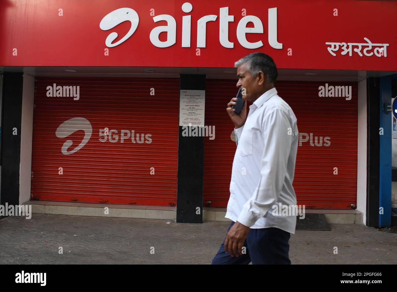 Mumbai, Inde. 22nd mars 2023. Un homme communiquant sur un téléphone portable passe devant le magasin Airtel de Mumbai. Airtel offre des données illimitées à ses 5G clients dans 26 villes. Elle couvrira l'ensemble des utilisateurs du pays, des zones rurales et urbaines d'ici la fin de mars 2024. (Photo par Ashish Vaishnav/SOPA Images/Sipa USA) crédit: SIPA USA/Alay Live News Banque D'Images