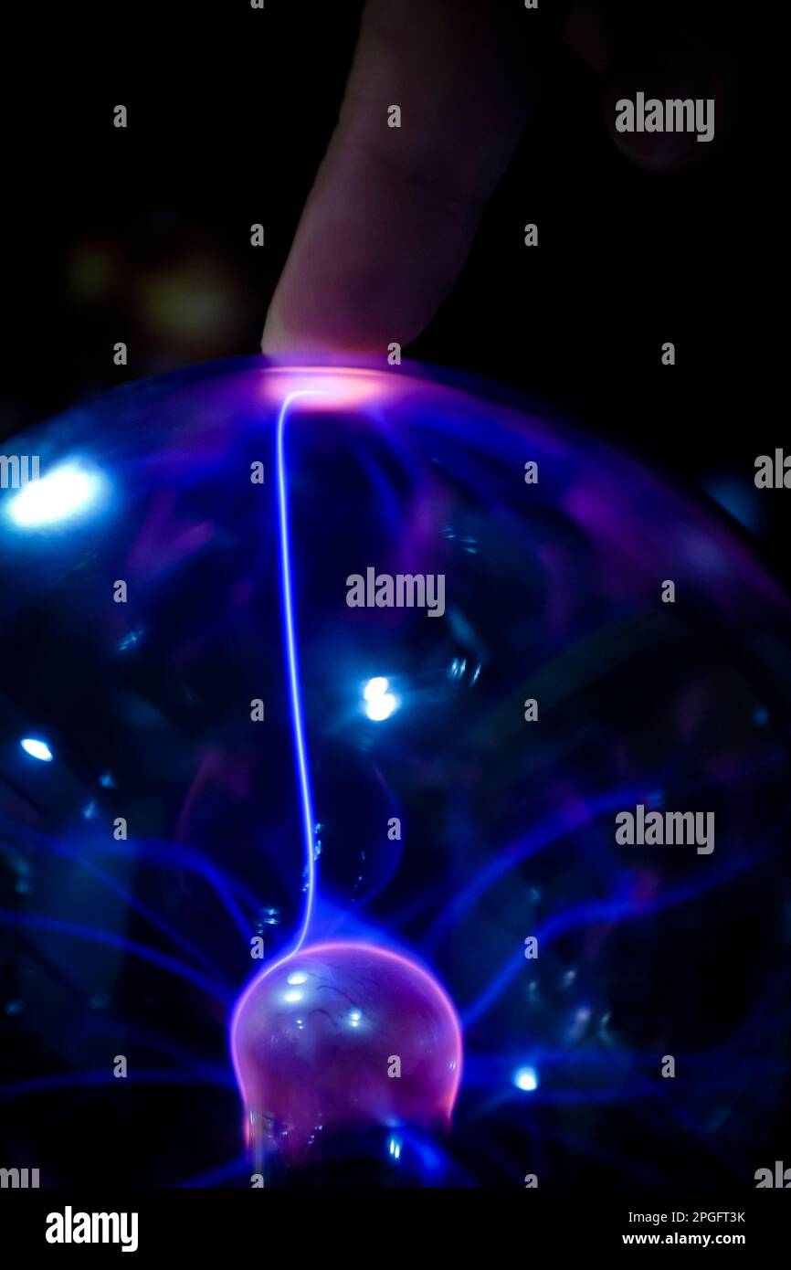 Doigt touchant une boule d'énergie avec un rayon de lumière qui traverse une sphère Banque D'Images