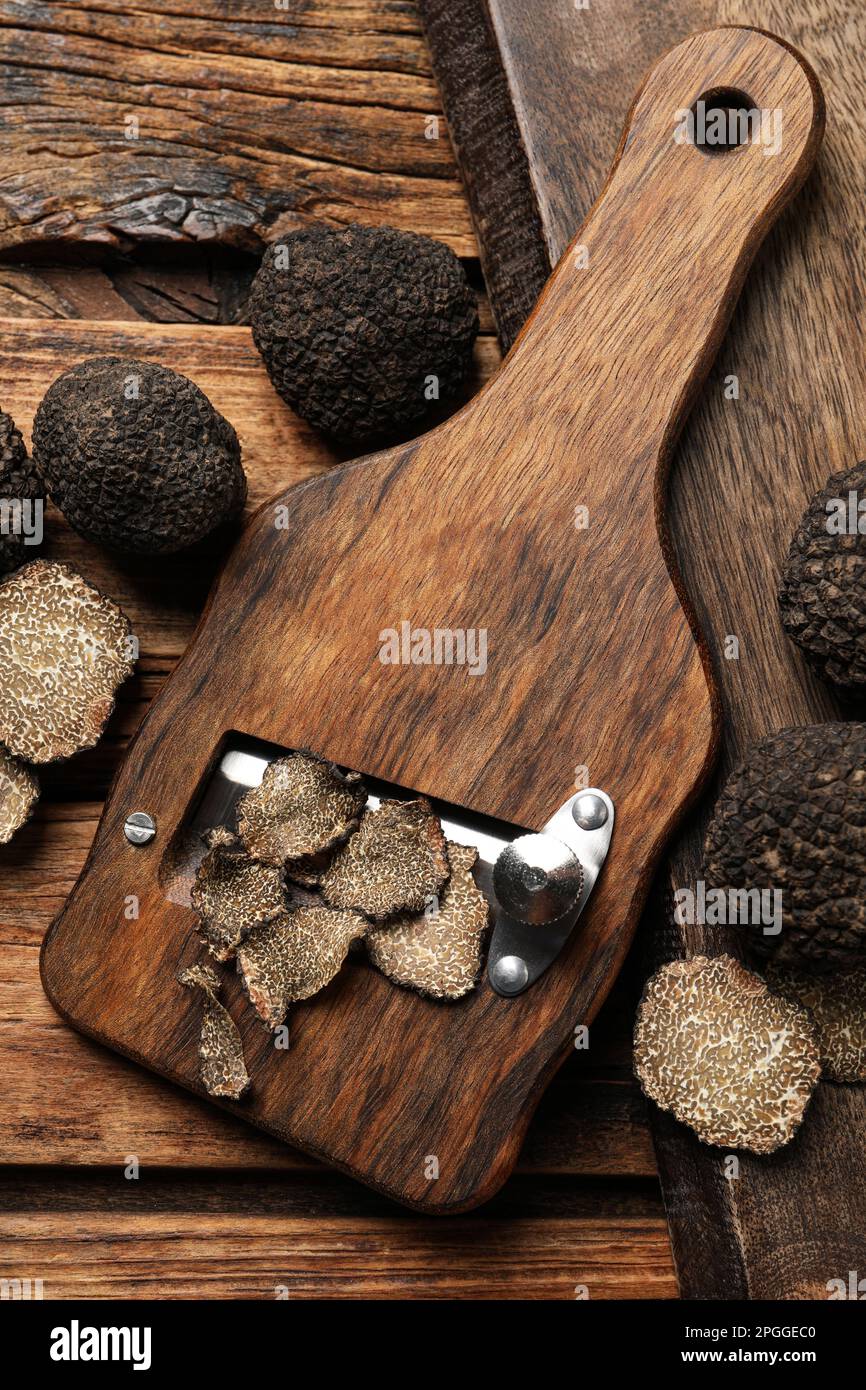 Rasoir Avec Truffes Noires Entières Et Tranchées Sur Table En Bois