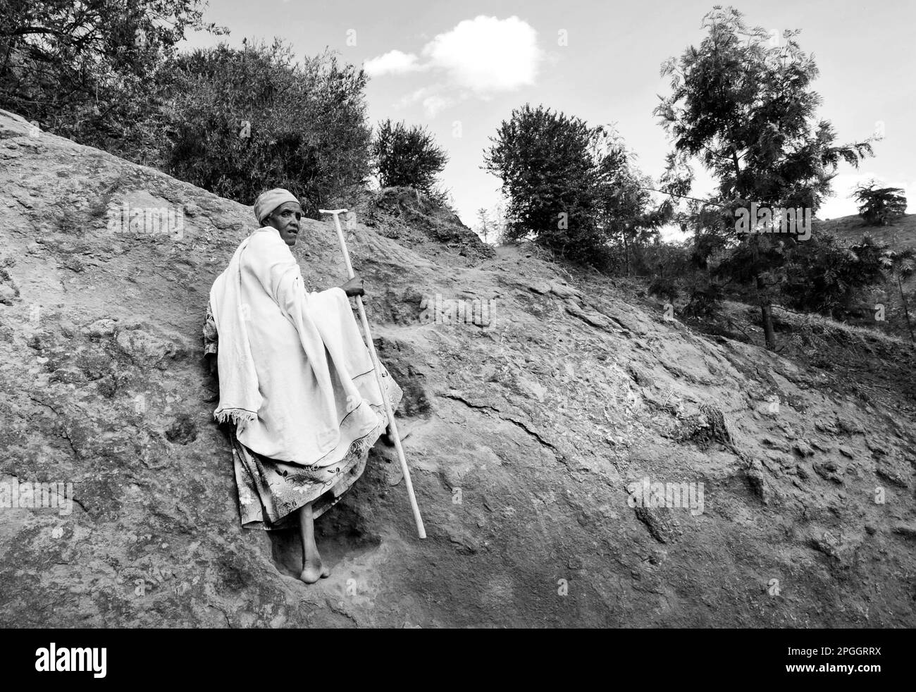 Une femme éthiopienne debout à l'extérieur d'une des églises sculptées dans le rocher à Lalibela, en Éthiopie. Banque D'Images