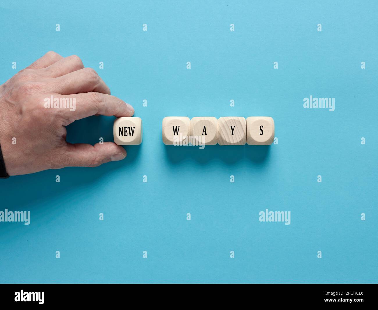 Nouvelles possibilités, méthodes, stratégies ou approches. La main masculine arrange les cubes en bois avec le mot nouvelles manières. Banque D'Images