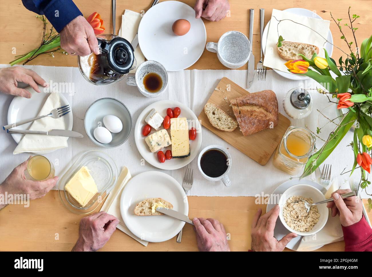 Groupe de personnes prenant le petit déjeuner ensemble sur une table en bois avec du pain, des œufs au fromage et du café, vue de dessus, sélection Banque D'Images