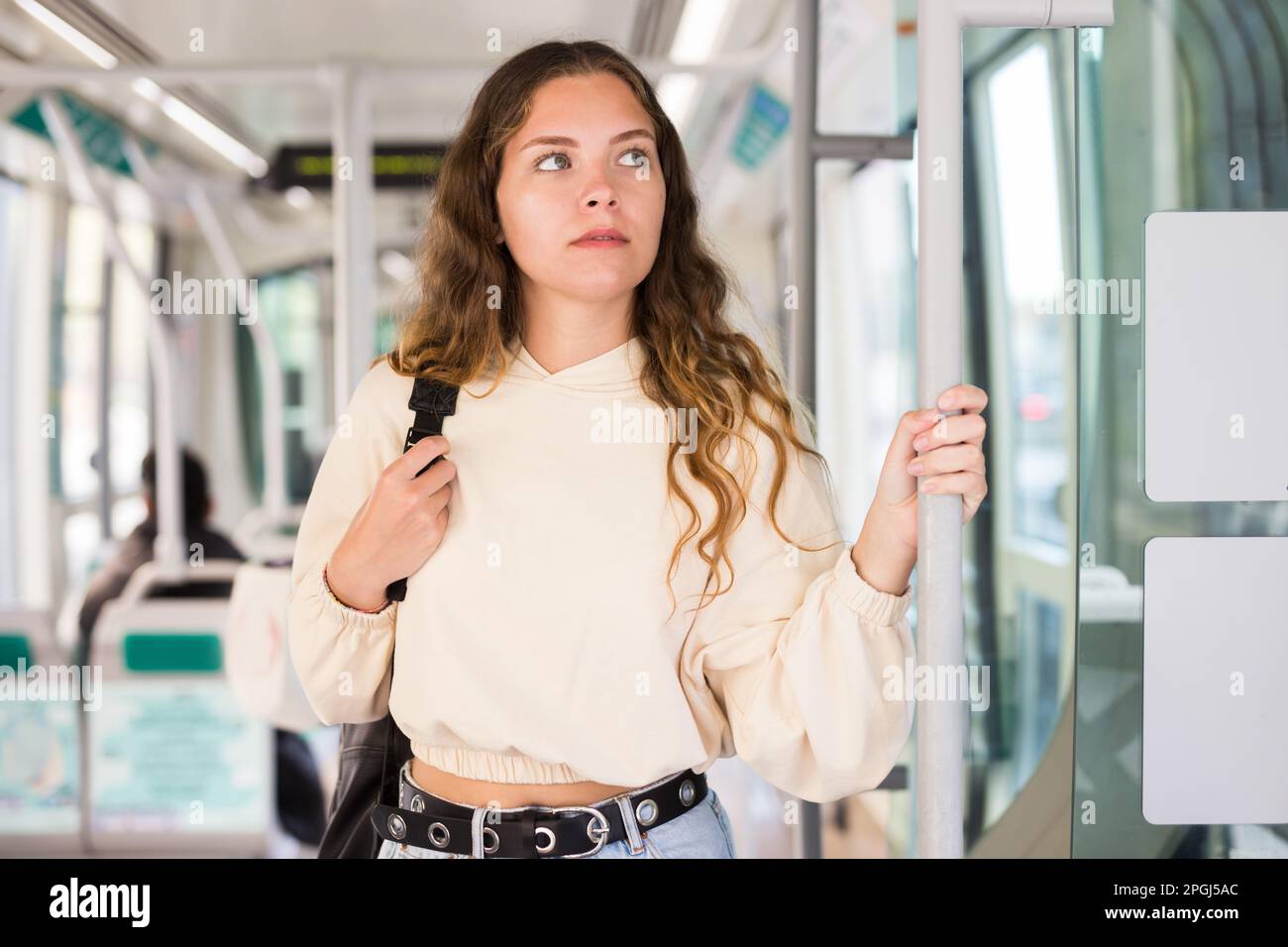 Jeune femme positive voyageant en tram Banque D'Images