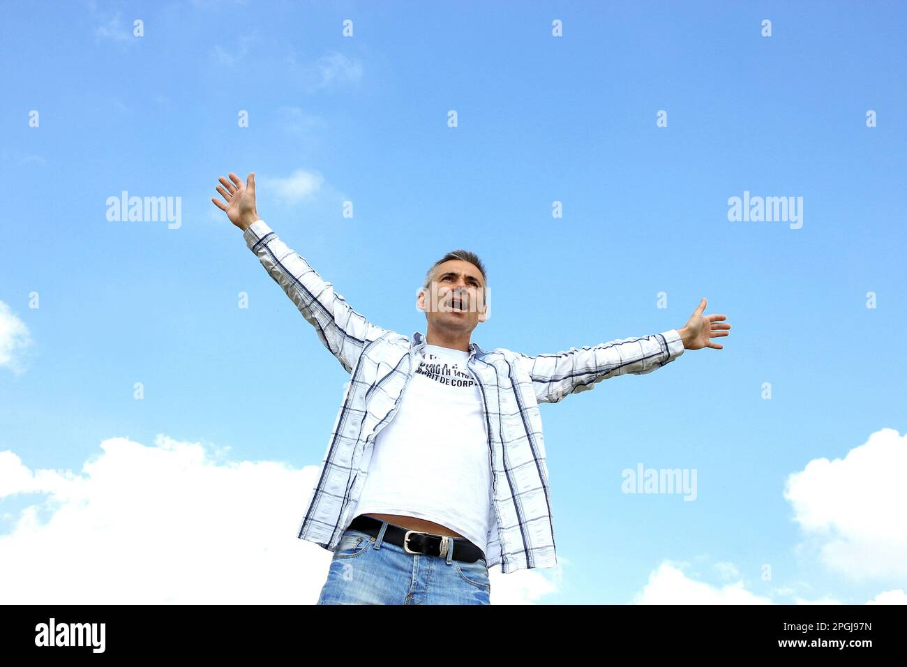 homme levant ses bras dans l'air en jubilation, vue de face Banque D'Images