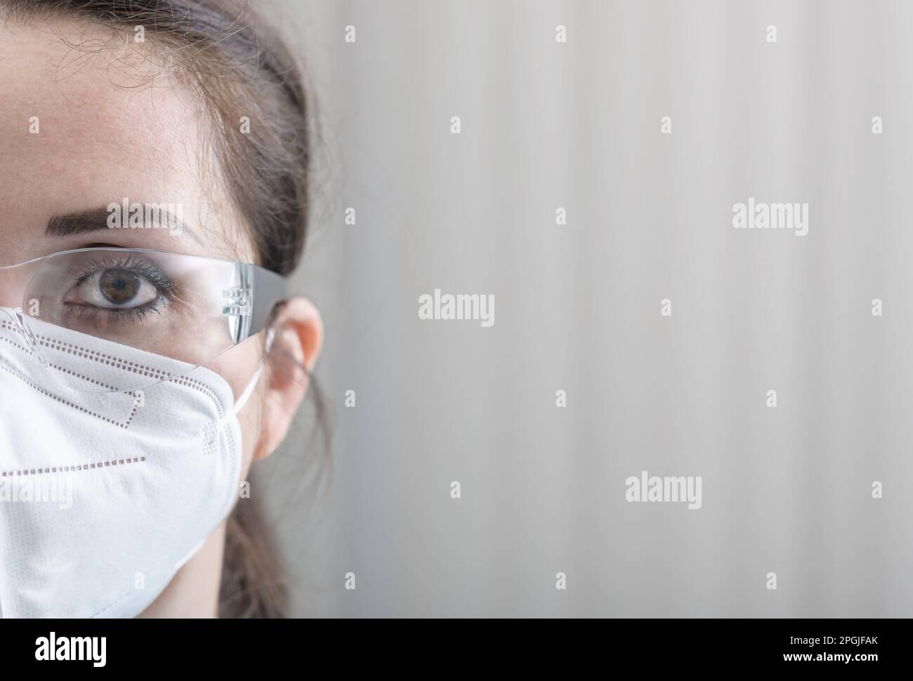 La moitié du visage de l'infirmière en gros plan protrait avec des lunettes de protection et N95 masque à l'hôpital Banque D'Images