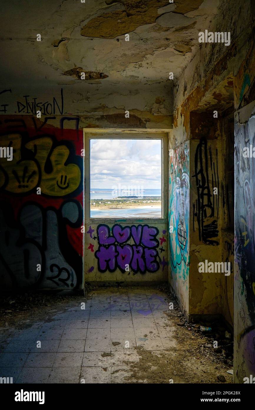Vue sur Tróia à travers une fenêtre d'une forteresse abandonnée dans la Serra da Arrabida à Setubal, où les murs sont couverts de graffiti. Banque D'Images