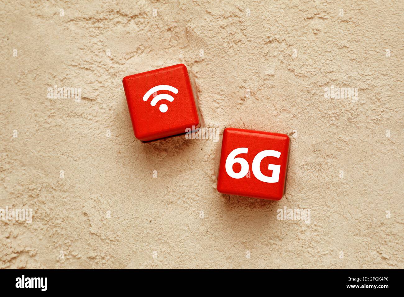 6G technologie, concept Internet. Cubes rouges avec symbole Wi-Fi sur sable, posé à plat Banque D'Images